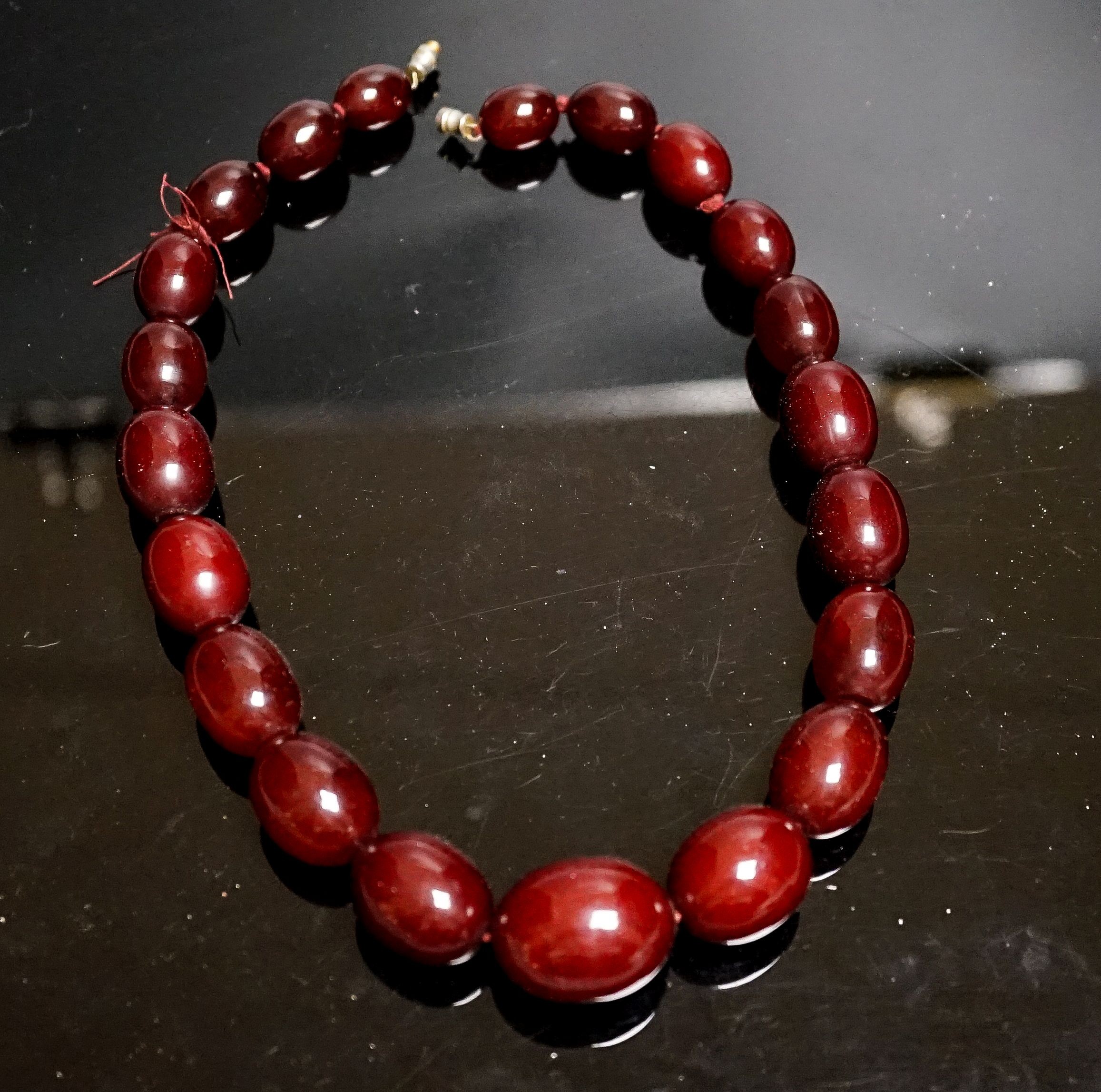 A single strand graduated simulated cherry amber oval bead necklace, 44cm, gross weight 78 grams.